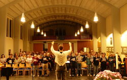 Der Riesenchor füllt schon die Hälfte der Sitzplätze im Kirchenschiff. Beim Auftritt werden die Sänger auf Podesten stehen.
