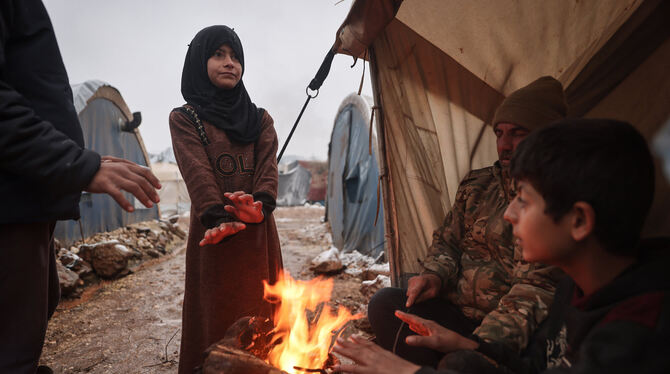 Syrische Binnenflüchtlinge wärmen sich an einem Feuer. FOTO: ALKHARBOUTLI/DPA Syrische Binnenflüchtlinge wärmen sich an einem Feuer. FOTO: ALKHARBOUTLI/DPA