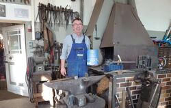 Josef Leippert mit der Plakette des Innenministers vor Amboss und Esse.