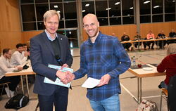 Bürgermeister Peter Nußbaum (links) nimmt zu Beginn der Gemeinderatssitzung die Petition für den Erhalt der Holzelfinger Schule