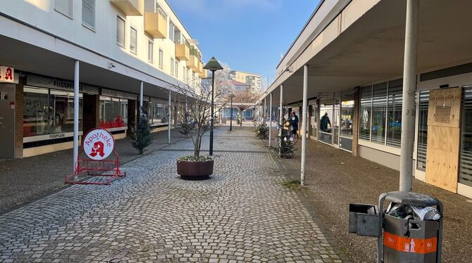 Das Zentrum von Orschel-Hagen mit Läden und Praxen, einer Seniorin mit Rollator und dem Haus der Begegnung im Hintergrund.
