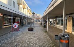 Das Zentrum von Orschel-Hagen mit Läden und Praxen, einer Seniorin mit Rollator und dem Haus der Begegnung im Hintergrund.