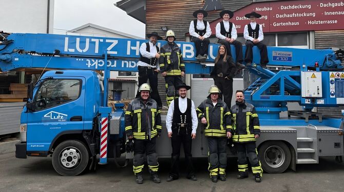Die Belegschaft der Lutz Holzbau GmbH posiert vor und auf einem Fahrzeug des Unternehmens. Jürgen Lutz (mittlere Reihe, links) u