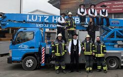 Die Belegschaft der Lutz Holzbau GmbH posiert vor und auf einem Fahrzeug des Unternehmens. Jürgen Lutz (mittlere Reihe, links) u