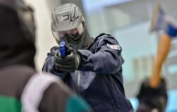 Ein Polizeibeamter übt die offensive Waffenhaltung bei einem fiktiven Angreifer mit einer Axt. Dass im Einsatz wirklich aus e