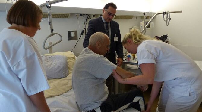 Elena Mirovic, Auszubildende im zweiten Lehrjahr, hilft dem Patienten Peter Lutz beim Aufrichten. Praxisanleiterin Katja Keppler Elena Mirovic, Auszubildende im zweiten Lehrjahr, hilft dem Patienten Peter Lutz beim Aufrichten. Praxisanleiterin Katja Keppler